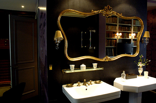black bathroom with gold mirror frame