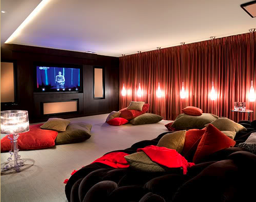 large home theater room with red curtains and hanging lights