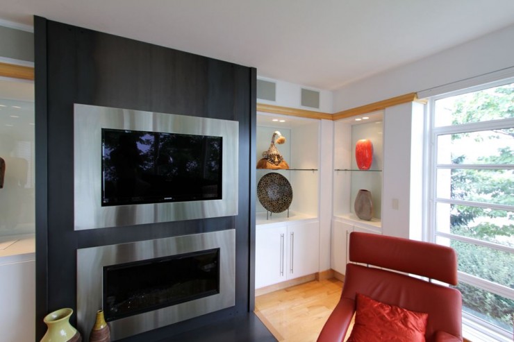 silver framed tv above fireplace