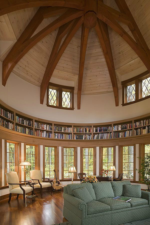 high ceiling with wood beams and a circular bookcase a