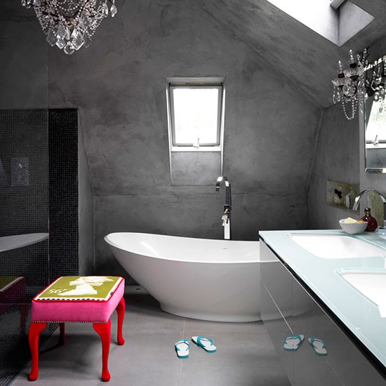 modern attic concrete bathroom with white bathtub and chandelier