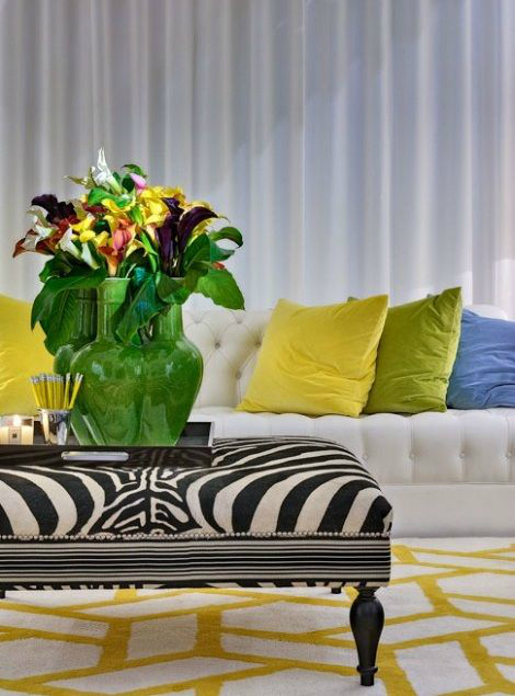 white living room with yellow blue and green pillows