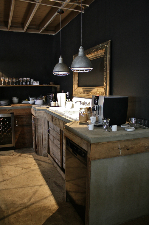 rustic industrial kitchen with black walls concrete counters