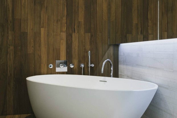 contemporary bathroom with wood wall and freestanding tub