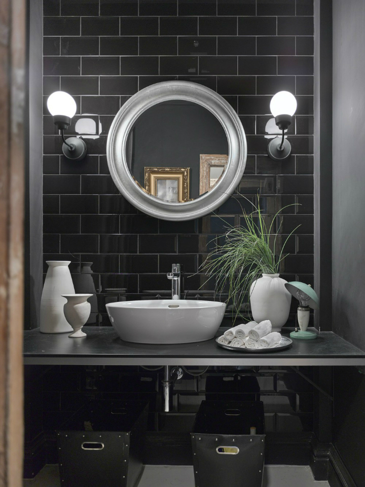 modern black bathroom with silver round mirror