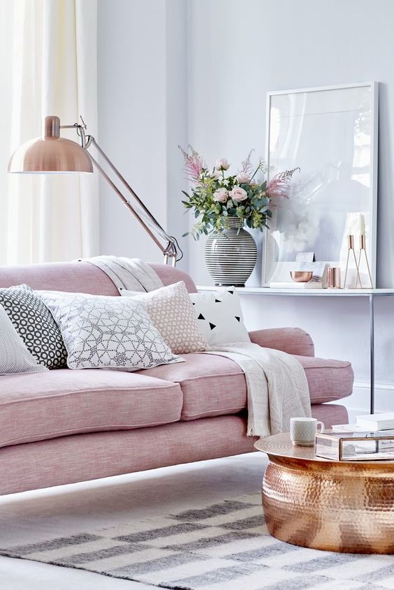 Feminine romantic living room with soft pink sofa and copper accents