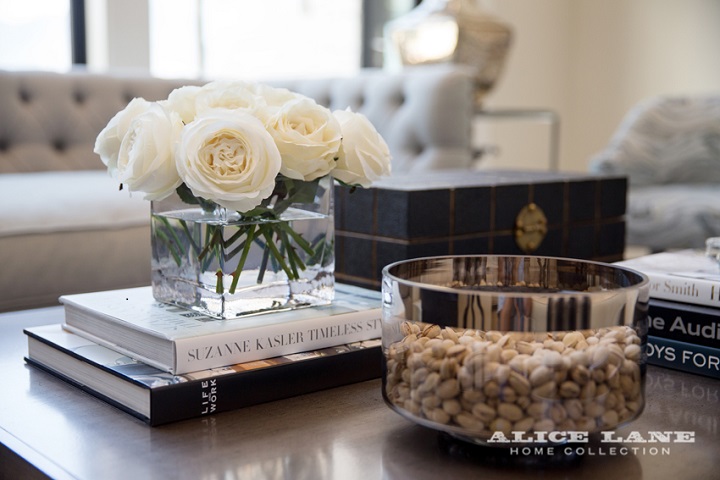 coffee table book and white flowers roses on living room table