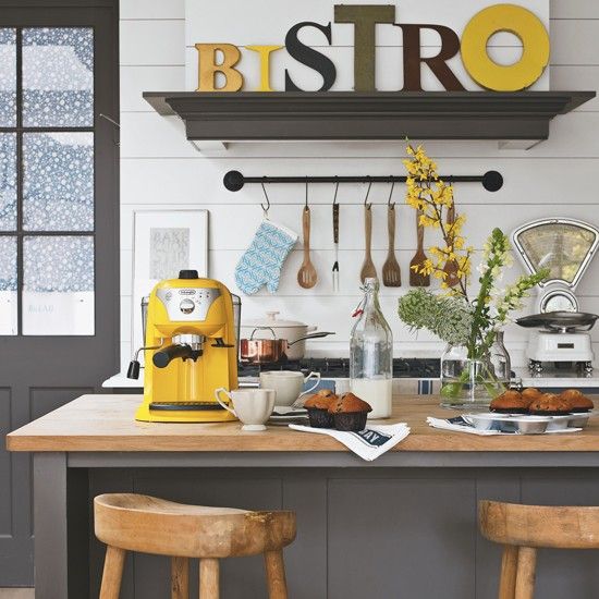 While the wooden stools and countertop are classic country, the bright yellow accessories and large letters on the shelf give this kitchen a new twist