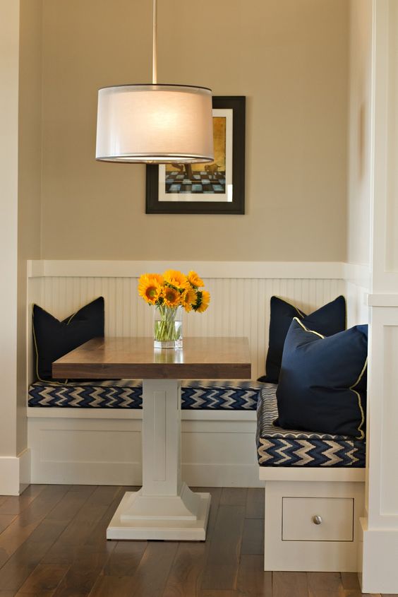 small breakfast nook with square table and solid navy pillows
