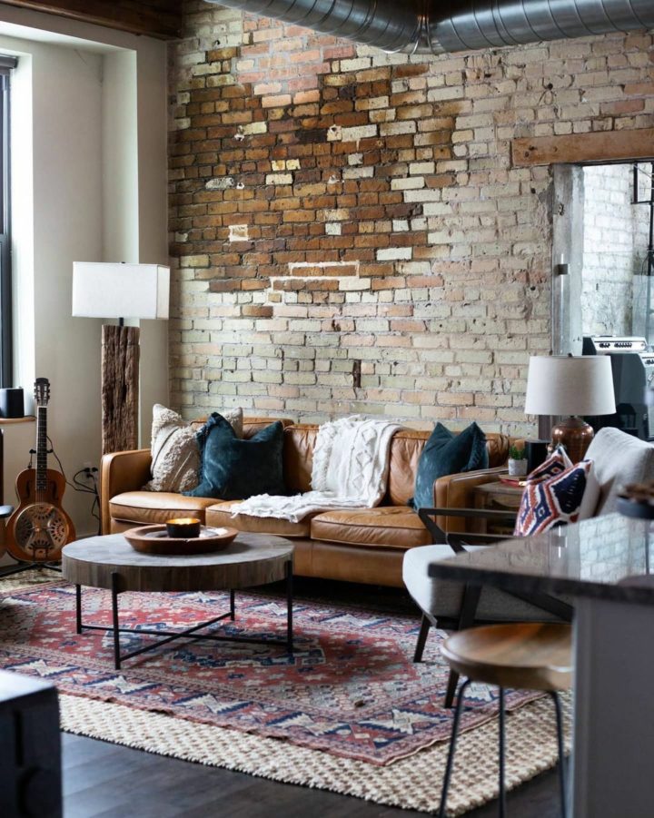 industrial living room with modern camel leather sofa and classic rug