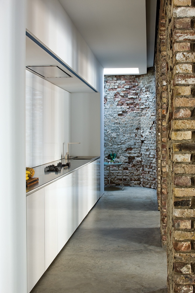 Industrial Minimalist white kitchen with brick wall