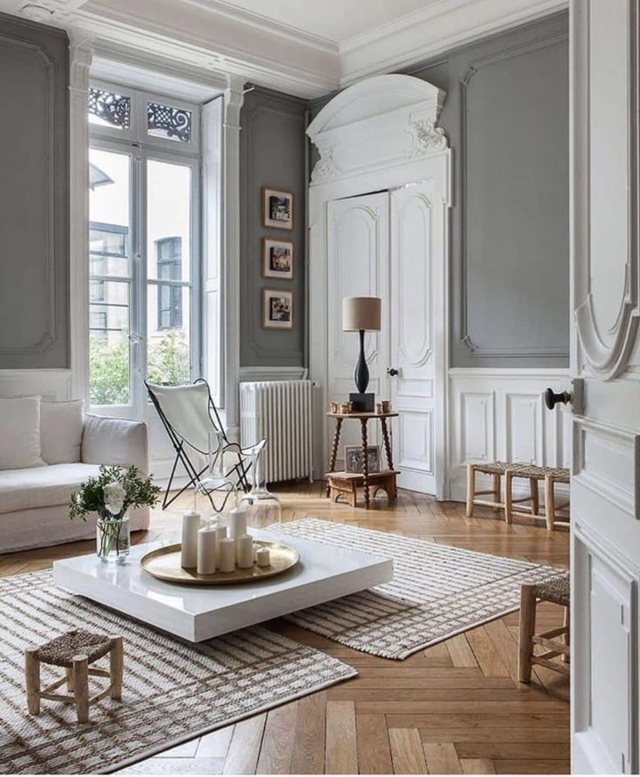  vardagsrum med grå väggar vita möbler trägolv och golv till tak fönster