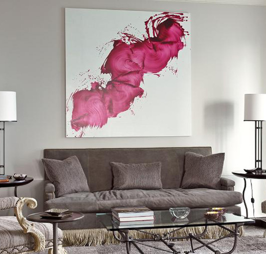 um sofá cinza com uma pintura especial acima 