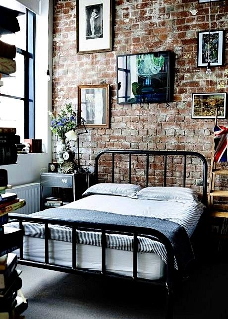 industrial bedroom with brick wall vintage art and black iron be