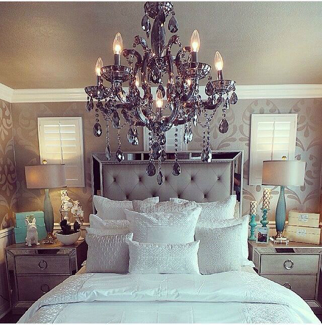 white bed and an impressive big chandelier