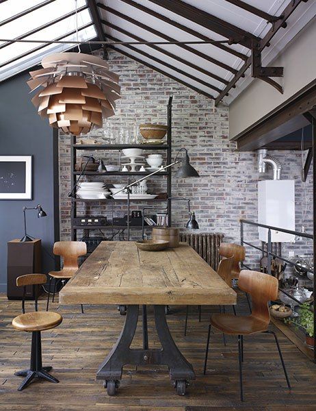 industrial dining room with thick wood top of this dining table is supported by a cast-iron factory table base