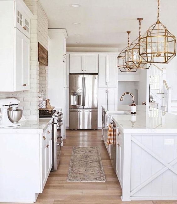 all white kitchen with white brick wall and brass/ gold accents