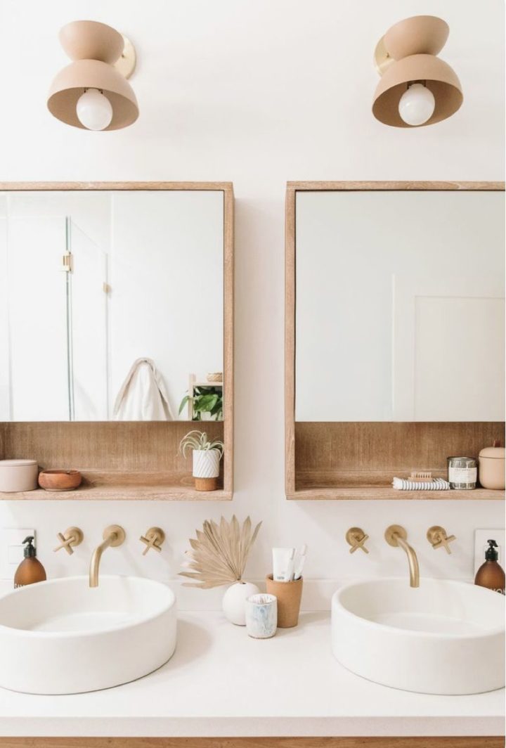 clear bathroom with double sink wood mirrors and gold faucets
