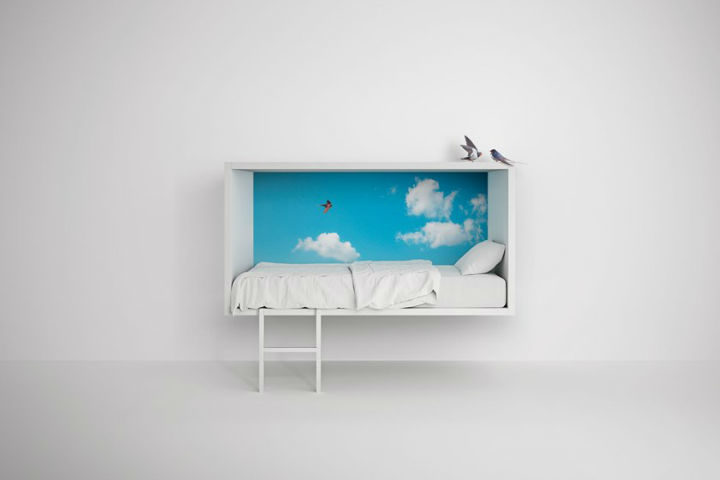 zoomed out image of a bed with sky painting for children