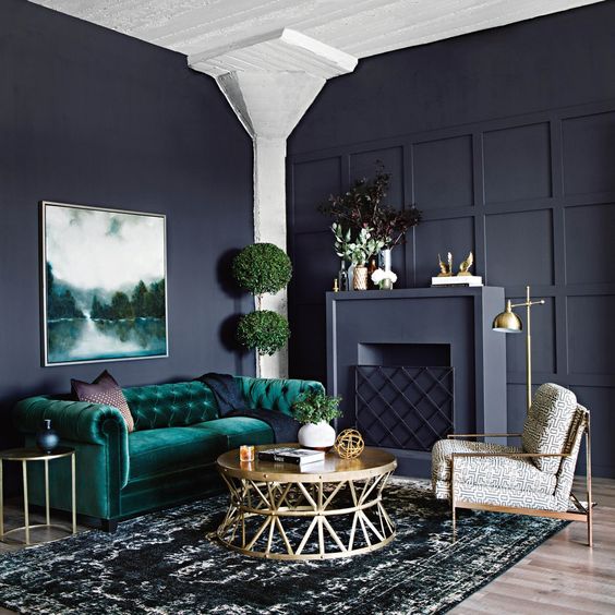 living room with green velvet sofa and black walls