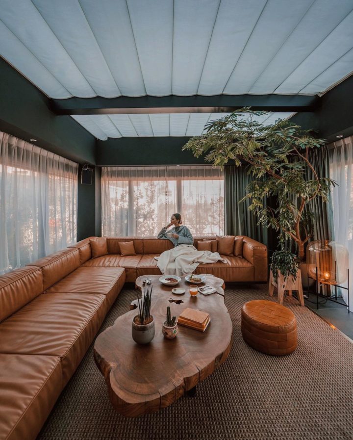 stue med snitt skinn brun sofa og svart vegg