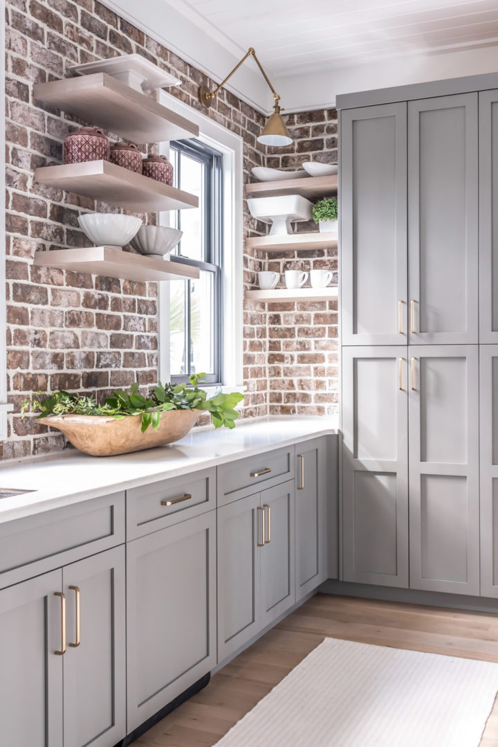 dove gray kitchen cabinets with brick wall