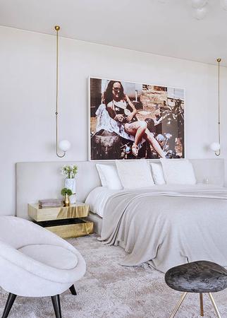 white bedroom with a big picture on the wall above bed
