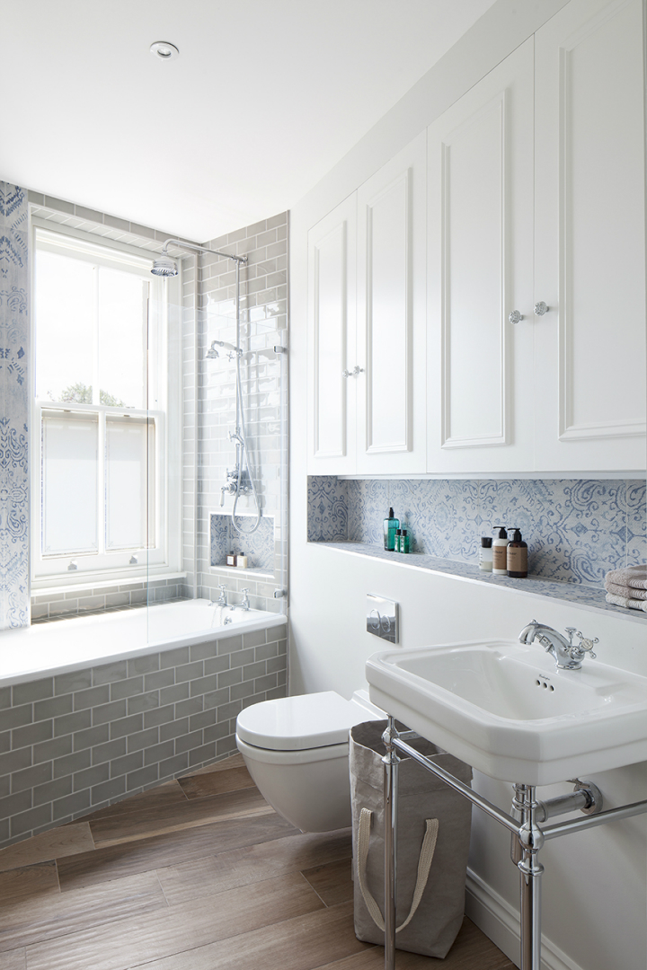 bathroom with grey metro tiles faux wood floor tile and Victorian print blue tile with a fabric-like texture.