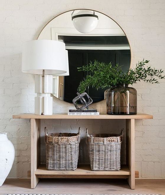 light-wood entryway table with elegant minimalism circular brass mirror
