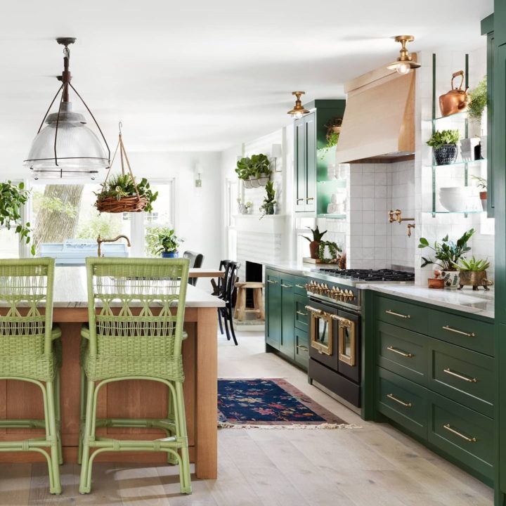 green kitchen withcopper range and vintage lights