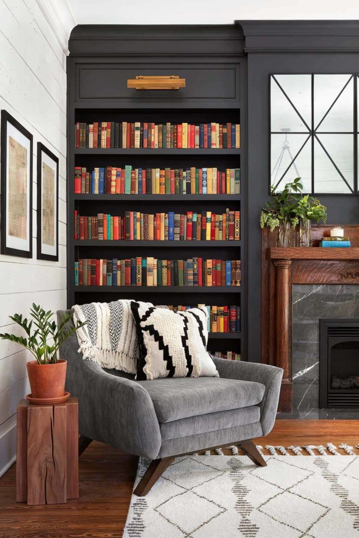 built in bookshelf beside fireplace and gray armchair