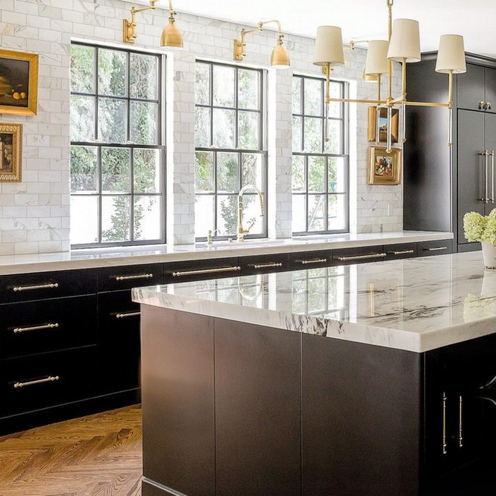 black kitchen with white marble countertop and white tiles and large windows