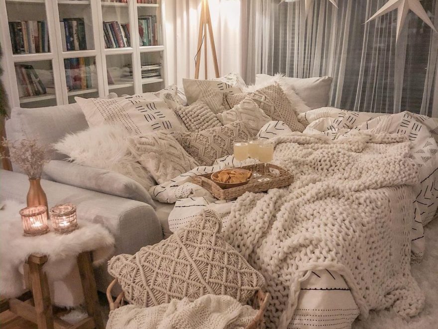 cozy hygge interior design idea with white sofa and white blankets