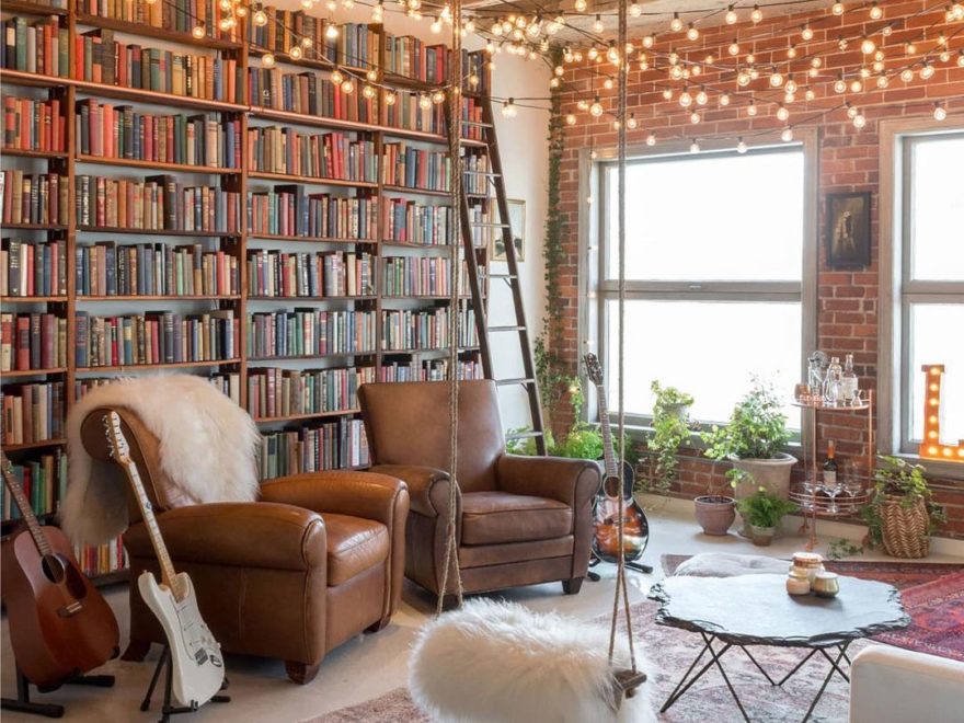 dream industrial loft with string lights, leather armchairs and library