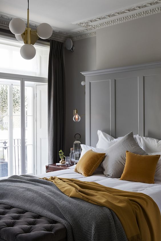 gray bedroom with mustard brown velvet pillows