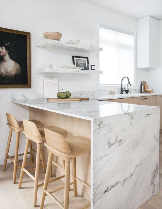 natural wood kitchen with marble worktop and peninsula with natural wood stools