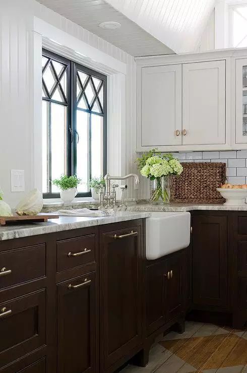 Dark brown cabinets with white upper cabinets and Cream Shaker Sink