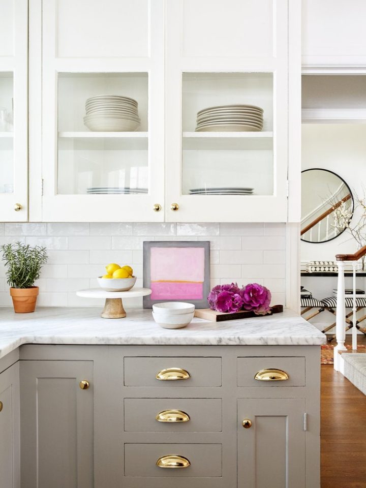 two toned white and beige kitchen cabinets with gold pulls and knobs