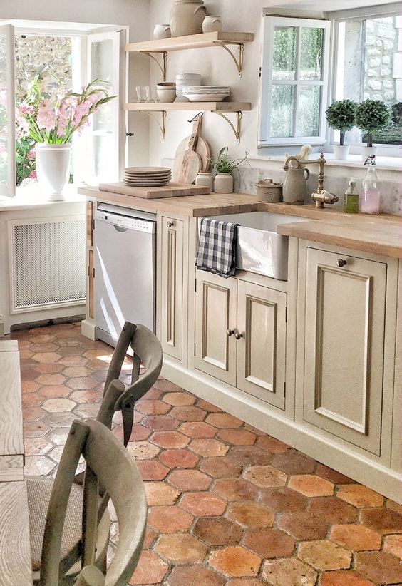 country kitchen with beige cabinets wood countertop and Terracotta hexagon flooring tiles