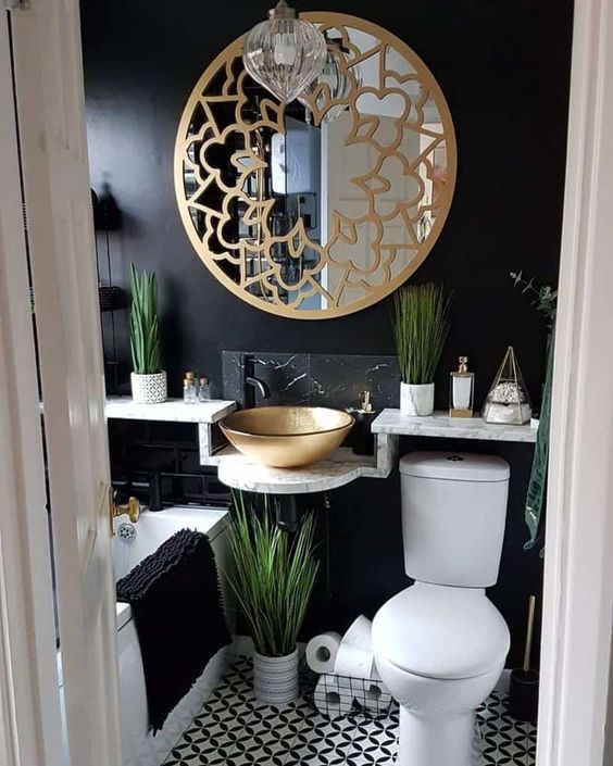 tiny bathroom with black wall gold free standing sink and bohemian gold round mirror