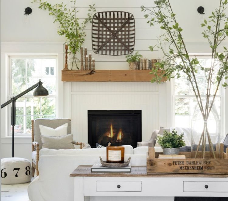 white farmhouse living room with fireplace with wood mantel and white reclaimed wood flooring