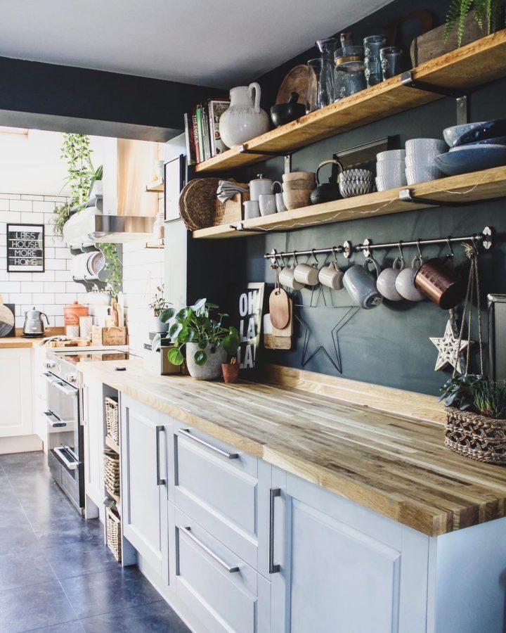 kitchen with white cabinets wood countertop wood open shelves and blue navy wall