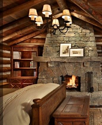 rustic bedroom with stone fireplace and wood library