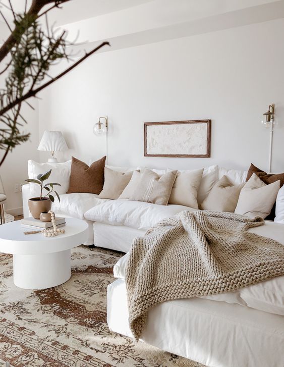 calm neutral living room with white sofa and beige blanket