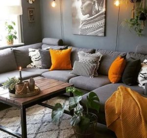 modern dark grey couch with orange pillows and dark grey wall