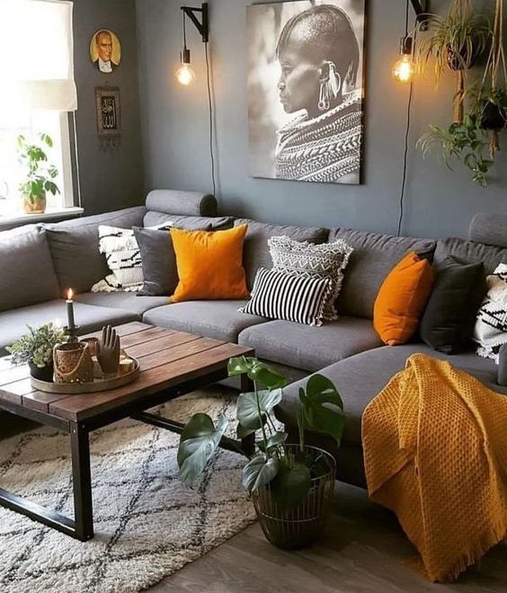 modern dark grey couch with orange pillows and dark grey wall