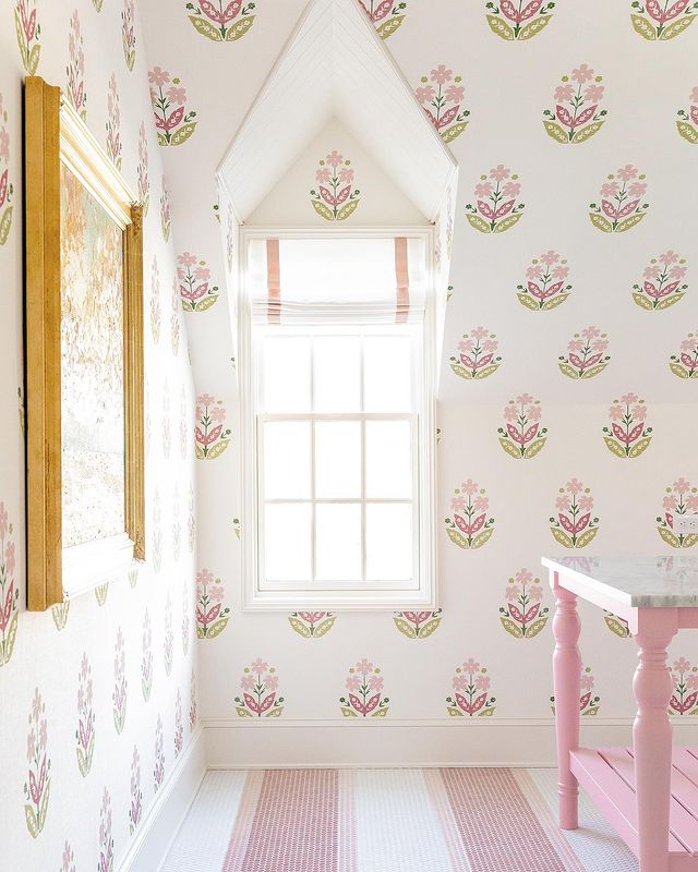 white and pink laundry room with wallpaper and pink island