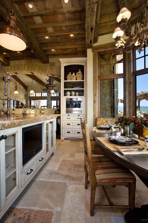 Tuscan kitchen with island and breakfast nook and stone flooring