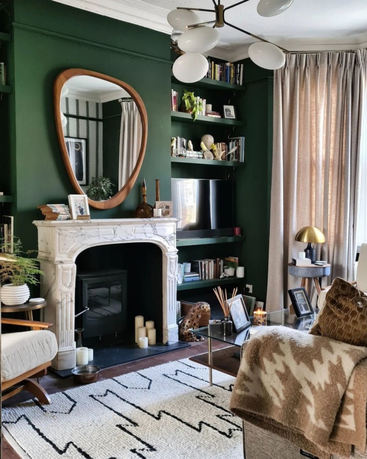 modern cozy living room with dark green accent wall with fireplace and shelves