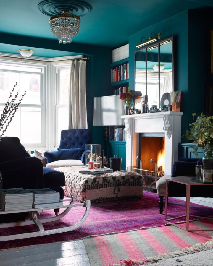 living-room-with-dark-green-walls-and-navy-velvet-armchair-and-purple-rug